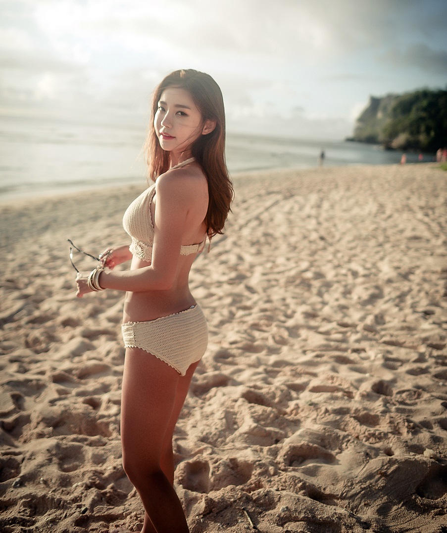 海边沙滩上的阳光肤色美女解开胸罩给男人吃奶图片